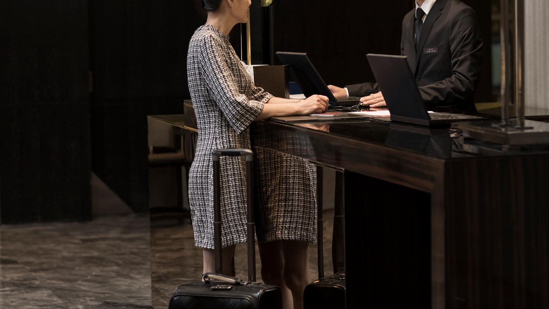 Elegant Chinese woman checking into hotel